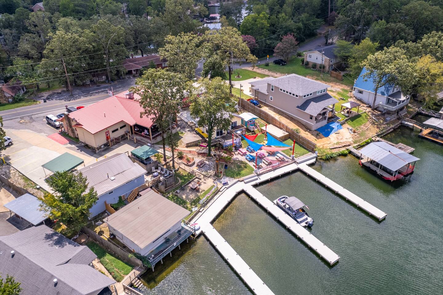 Drone aerial of Sam's Pizza Pub, the lakeside patio, and the dock on Lake Hamilton